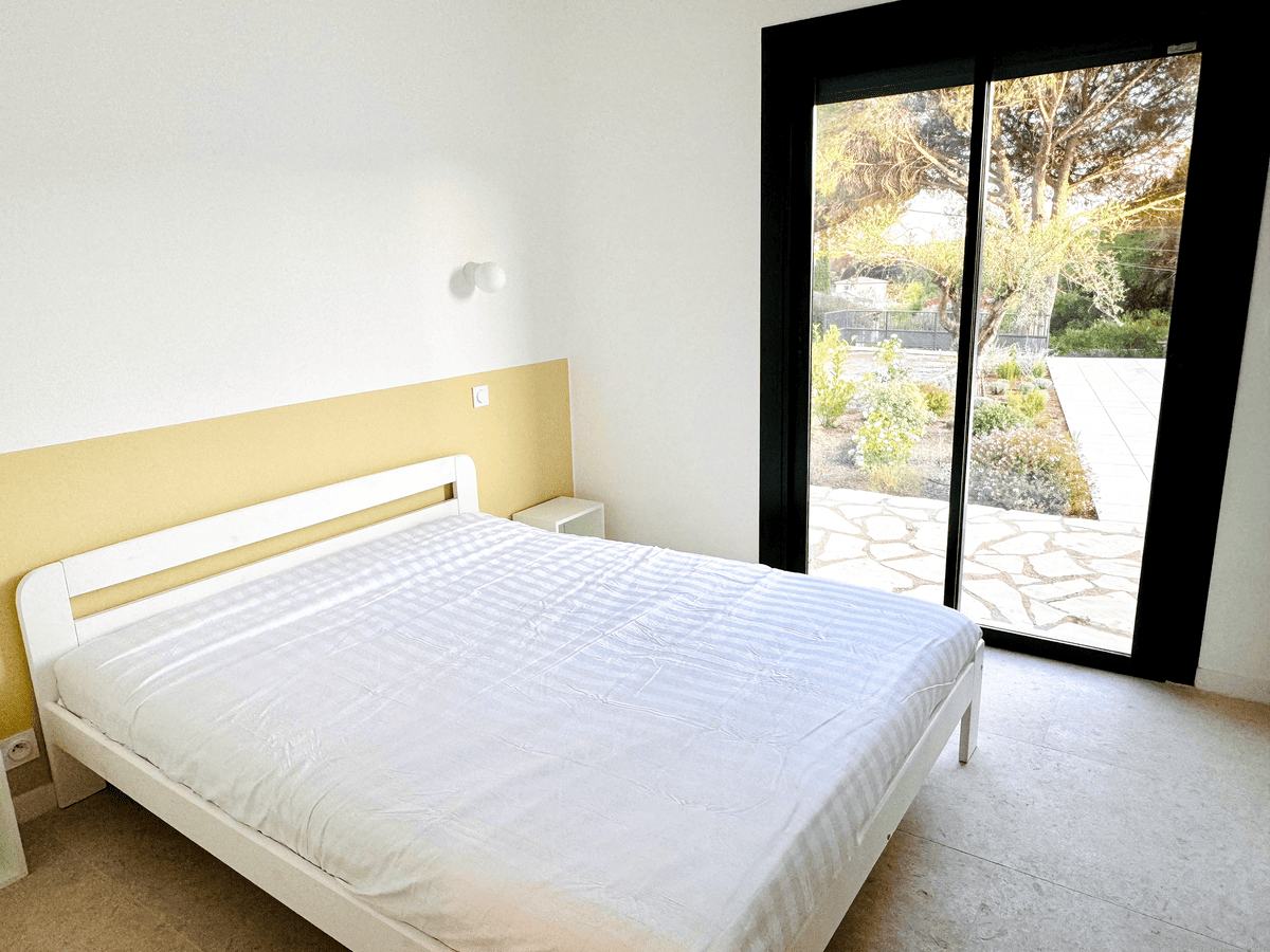 Chambre parentale avec vue sur le jardin méditerranéen de la Villa Réal à Puget-sur-Argens